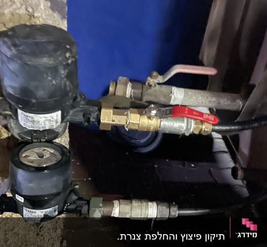 מד מים וצינורות עם ברזים במערכת אינסטלציה